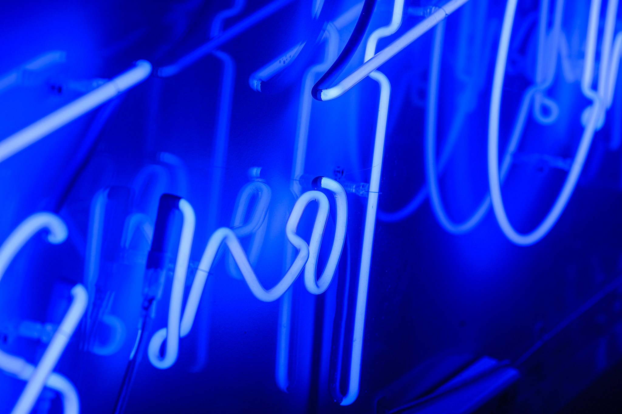 A close up of the word 'not' in blue marine neon lights in a stylised handwritten font